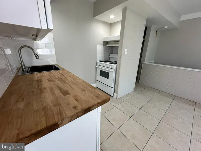 a kitchen with white cabinets and sink