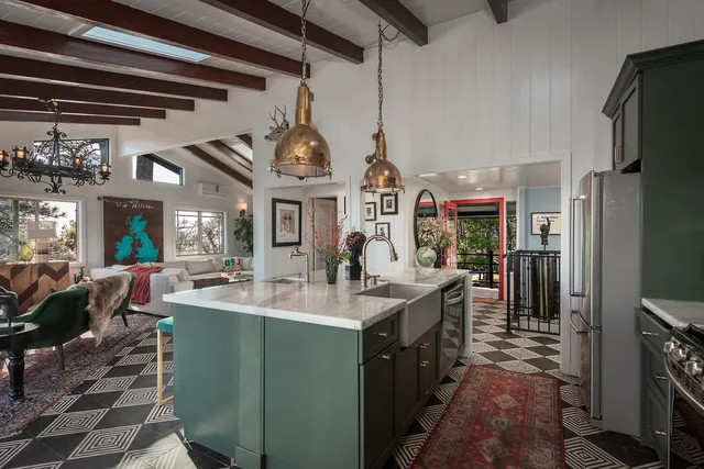 a living room with furniture dining table a large window and a potted plant