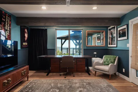 a view of a balcony with chairs and wooden floor