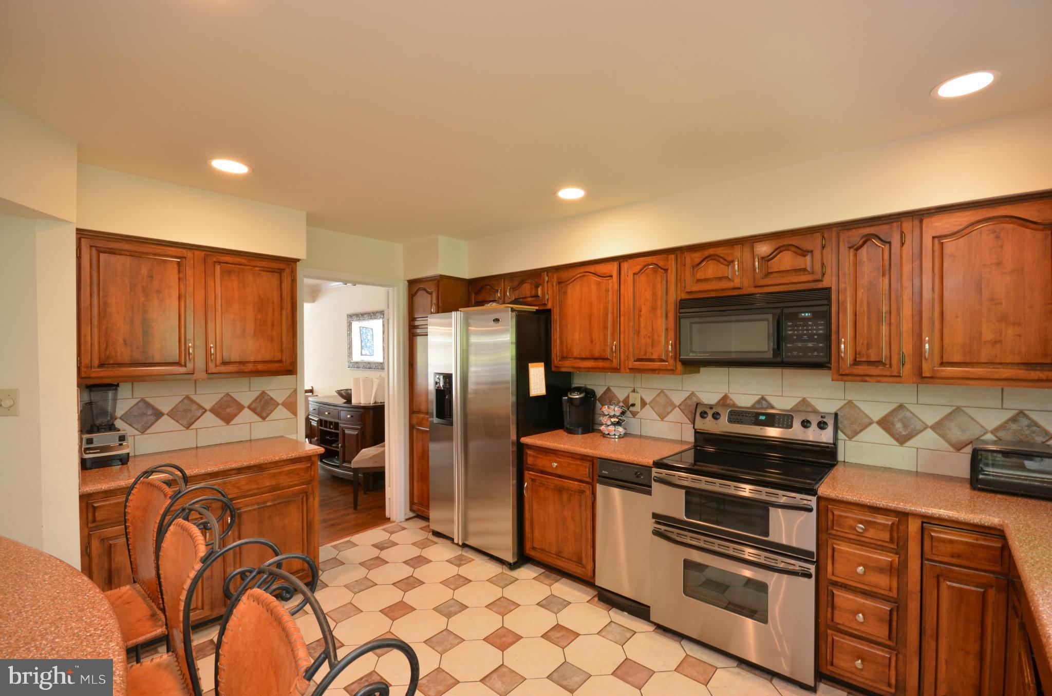 10771 Brewer House Road Rockville, MD 20852 - Photo 11 of 30 a kitchen with stainless steel appliances granite countertop a refrigerator stove and sink