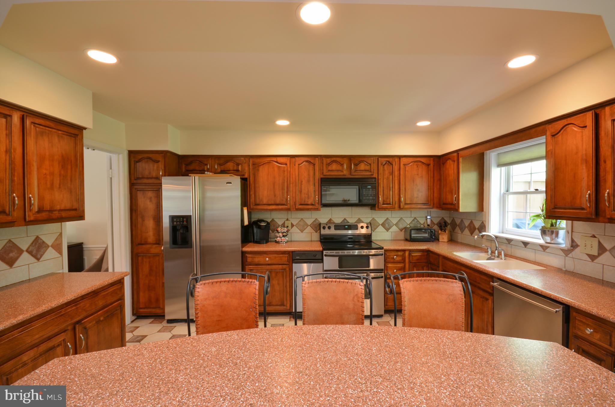 10771 Brewer House Road Rockville, MD 20852 - Photo 9 of 30 a kitchen with stainless steel appliances a sink a stove a refrigerator cabinets and a dining table