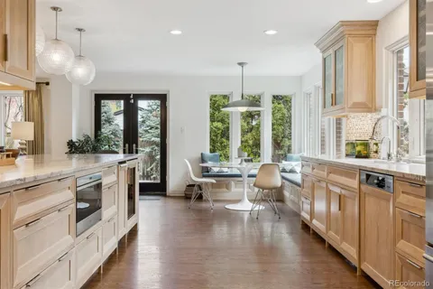 a large white kitchen with a large window and stainless steel appliances