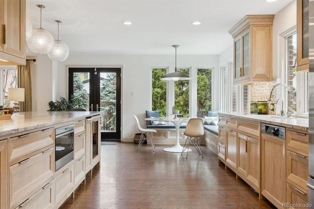 a large white kitchen with a large window and stainless steel appliances