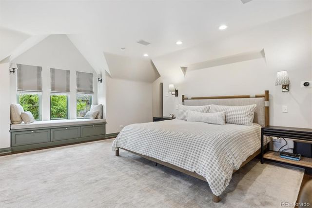 a spacious bedroom with a bed a couch and a window