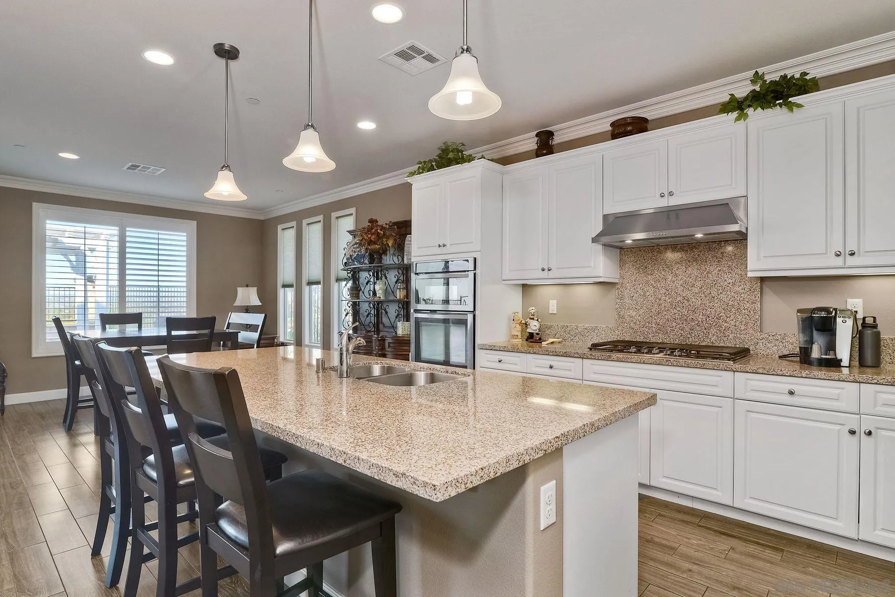 446 Adobe Estates Drive Vista, CA 92083 - Photo 4 of 15 a kitchen with stainless steel appliances granite countertop a stove center island a table and chairs