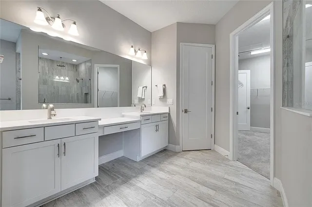 a bathroom with a double vanity sink a mirror and a shower