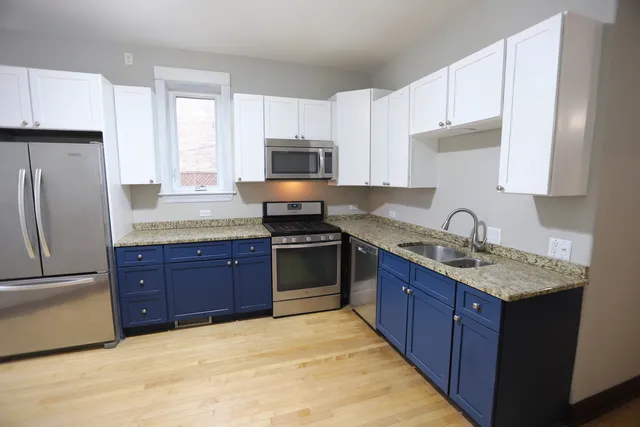 a kitchen with granite countertop a sink stove and refrigerator