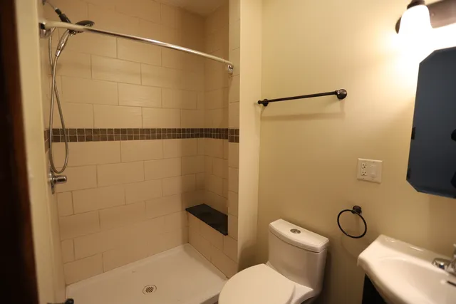 a bathroom with a shower a toilet and a sink