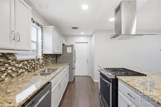 a kitchen with sink stove and cabinets