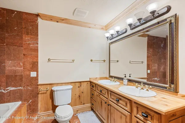 a bathroom with a sink vanity granite and toilet