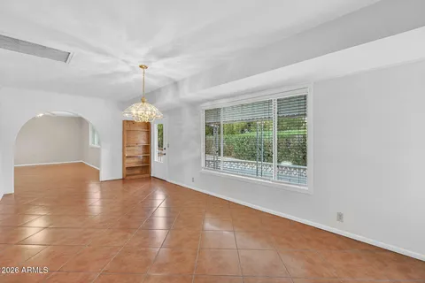 an empty room with windows and chandelier