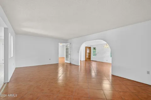 a view of empty room with wooden floor and window
