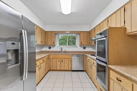a kitchen with stainless steel appliances granite countertop a refrigerator and a stove top oven