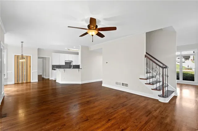 a view of empty room with wooden floor and ceiling fan