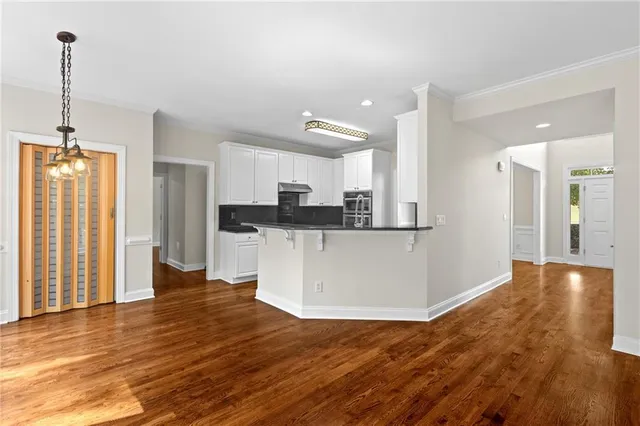 a view of a kitchen with cabinets and wooden floor
