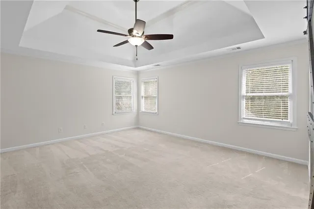 an empty room with windows and fan