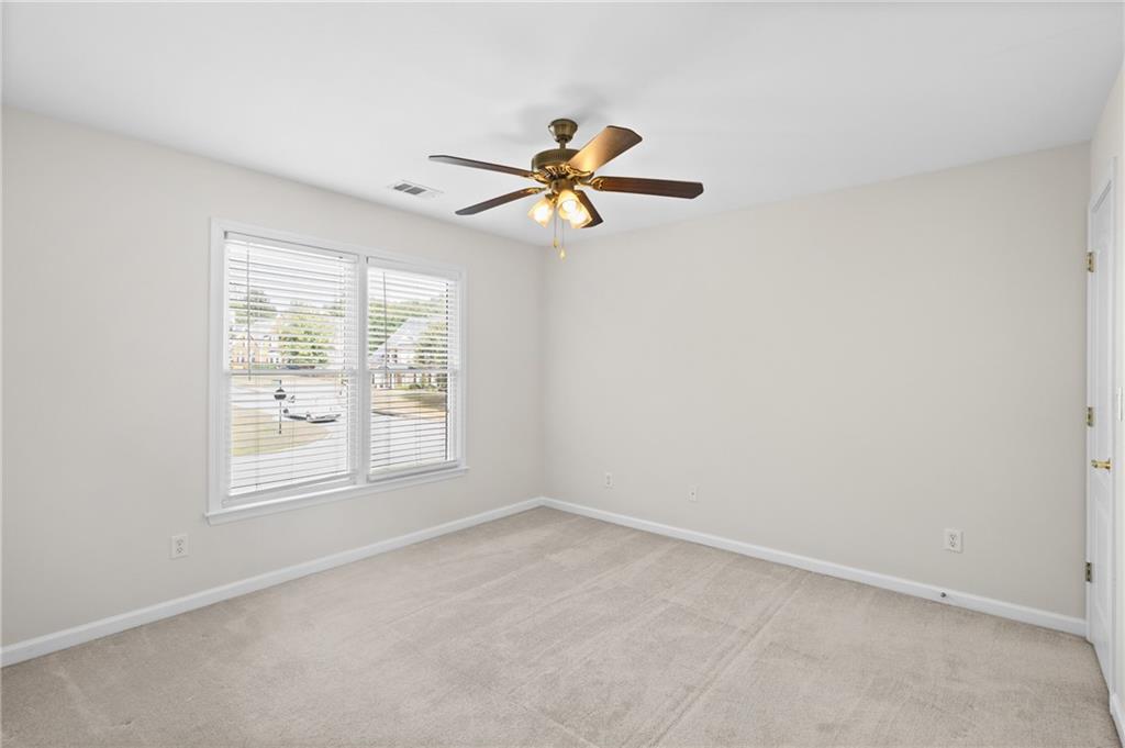 3685 Rolling Creek Drive Northeast Buford, GA 30519 - Photo 25 of 48 an empty room with windows and fan
