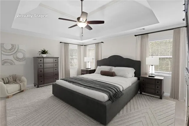 a bedroom with a large bed and ceiling fan