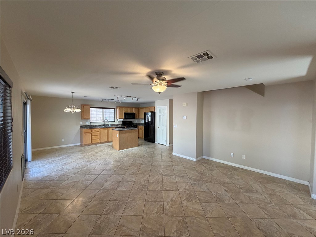 7613 Roop Street Las Vegas, NV 89131 - Photo 7 of 25 Tiled flooring stretches across this open layout connecting the main living area and kitchen.