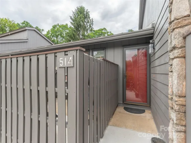 a side view of a house with a wooden fence