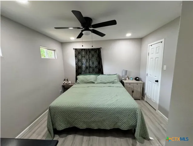 a bedroom with a bed and a ceiling fan
