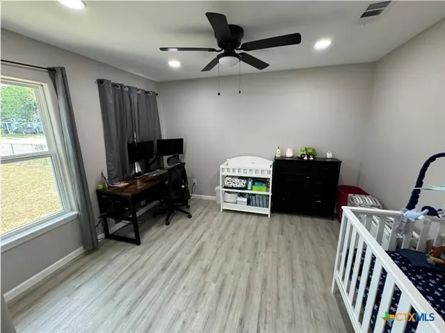 a view of a workspace with furniture and a window