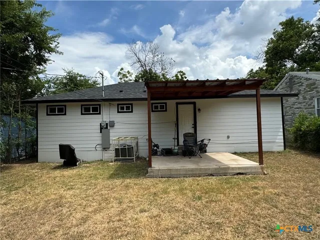 a view of a house with backyard and sitting area