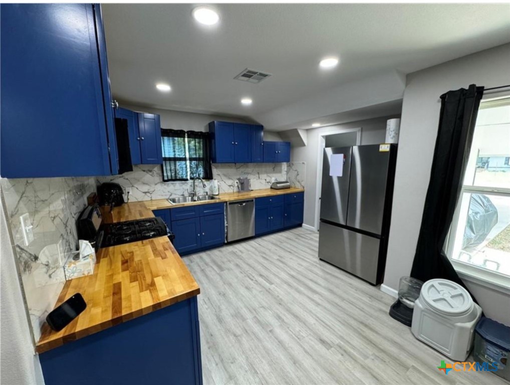 2409 Mitchell Avenue Waco, TX 76708 - Photo 4 of 17 a kitchen with kitchen island a counter top space a sink stainless steel appliances and cabinets
