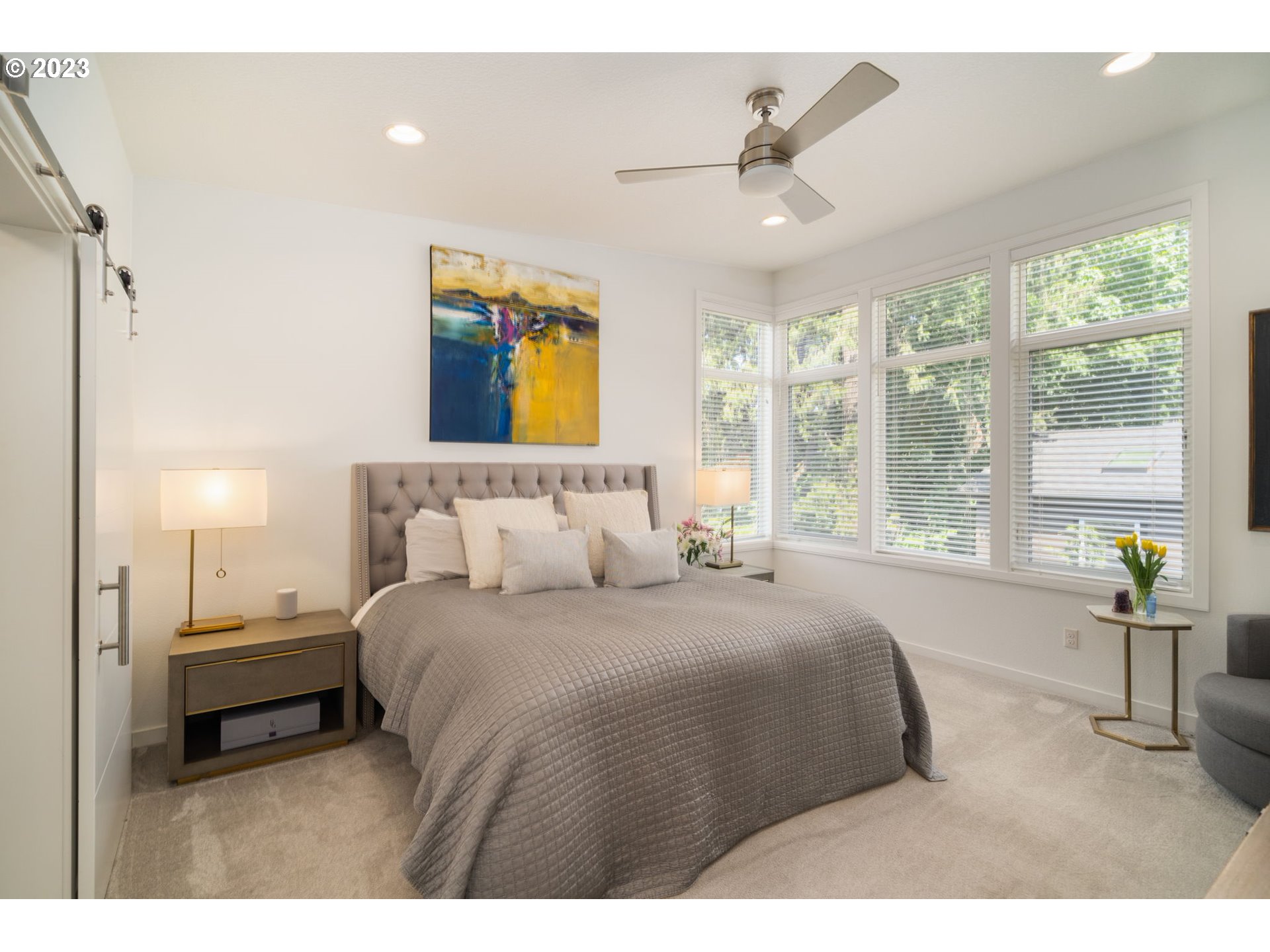 7660 Southwest 36th Avenue Portland, OR 97219 - Photo 13 of 40 a bedroom with a large bed and a chandelier
