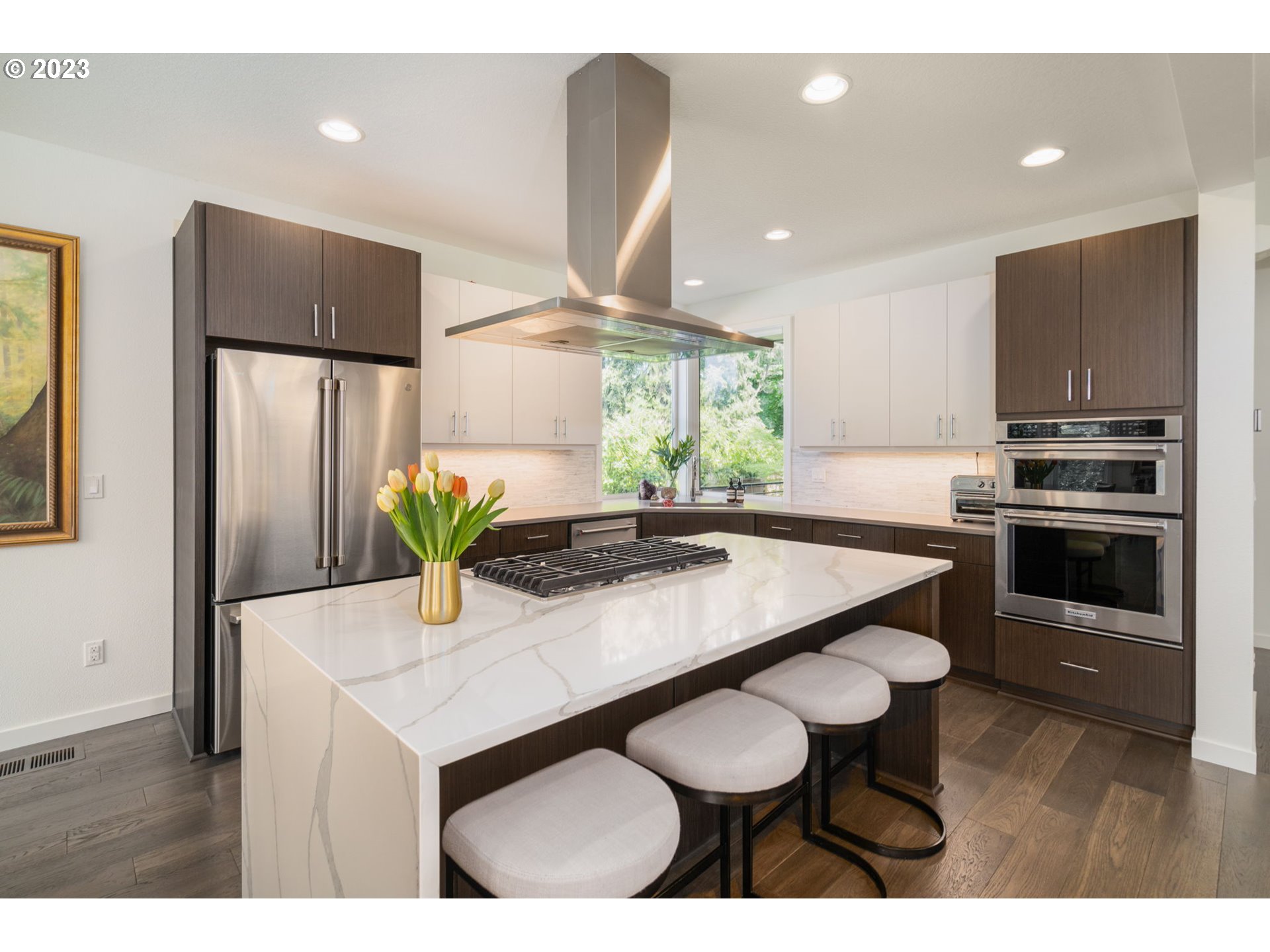 7660 Southwest 36th Avenue Portland, OR 97219 - Photo 10 of 40 a kitchen with stainless steel appliances a dining table chairs refrigerator and microwave