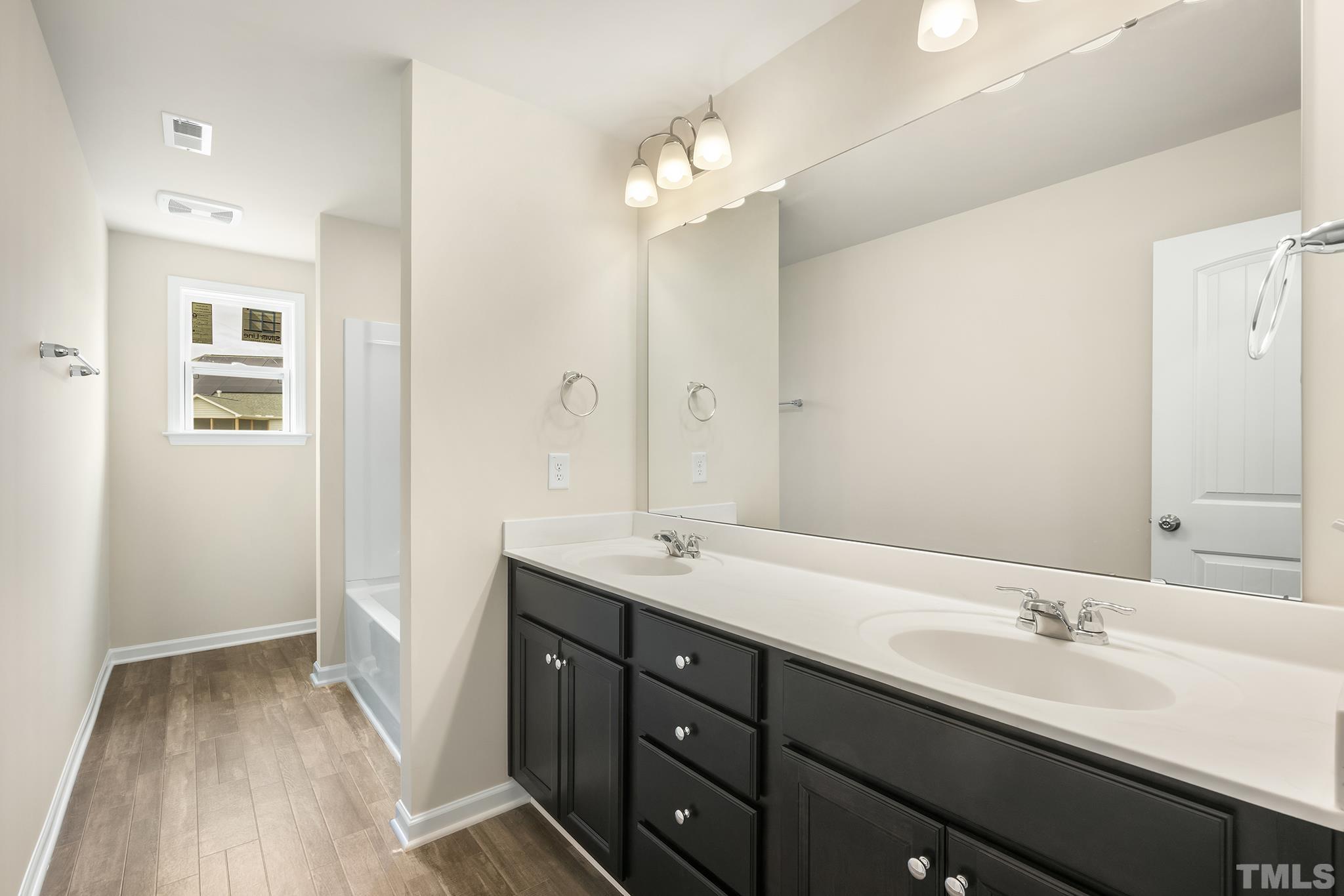 166 Karlov Road Garner, NC 27529 - Photo 5 of 29 a bathroom with a double vanity sink and a mirror