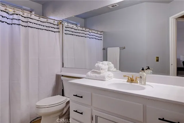 a bathroom with a sink a toilet and shower curtain