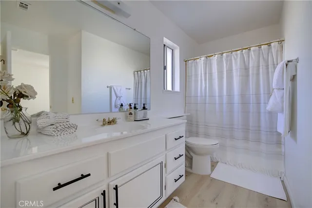 a bathroom with a double vanity sink toilet and shower