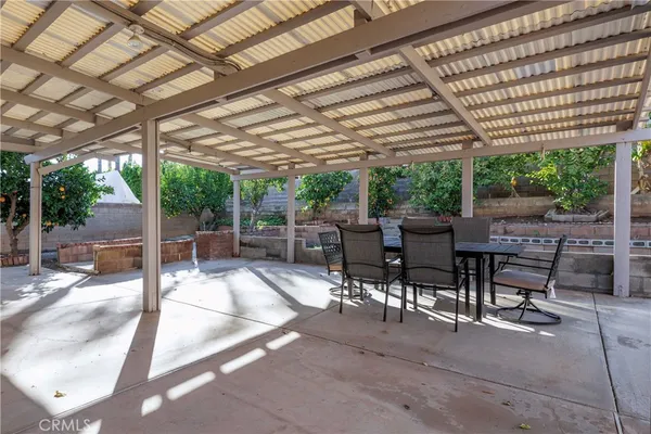 a view of a patio with a table and chairs under a large umbrella