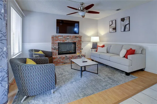 a living room with furniture a flat screen tv and a fireplace