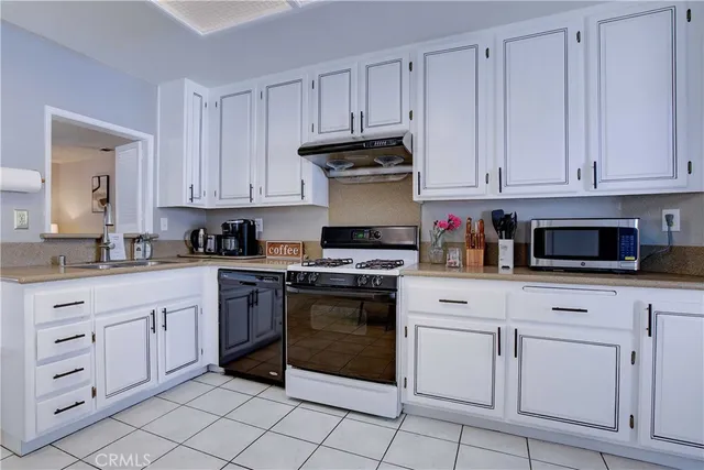 a kitchen with white cabinets and white appliances