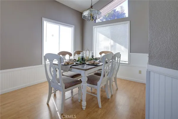 a dining room with furniture a chandelier and wooden floor