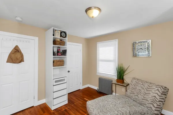 an empty room with wooden floor closet and windows