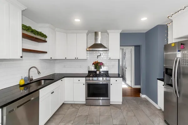 a kitchen with stainless steel appliances a stove a sink and a refrigerator