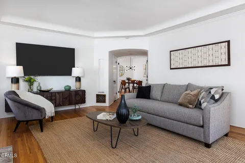 a view of a hallway with wooden floor and furniture