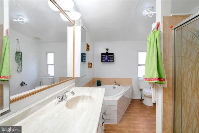 a bathroom with a tub a sink and a large mirror