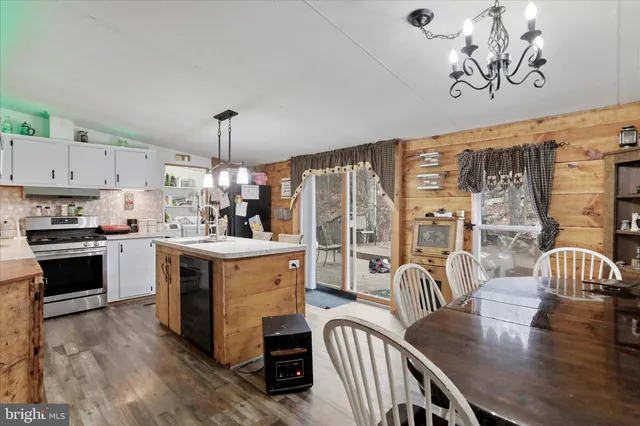 a kitchen with a table chairs stove and white cabinets