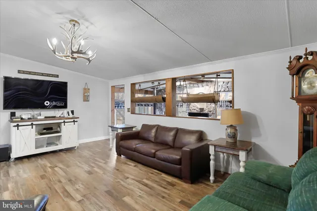 a living room with furniture a flat screen tv and kitchen view