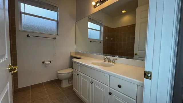 a bathroom with a double vanity sink toilet and mirror