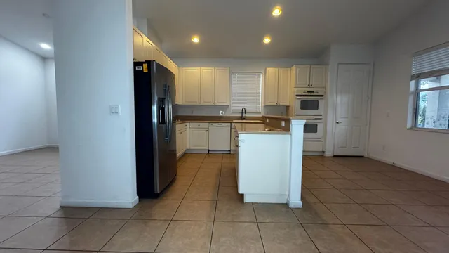 a kitchen with stainless steel appliances granite countertop a refrigerator and a stove