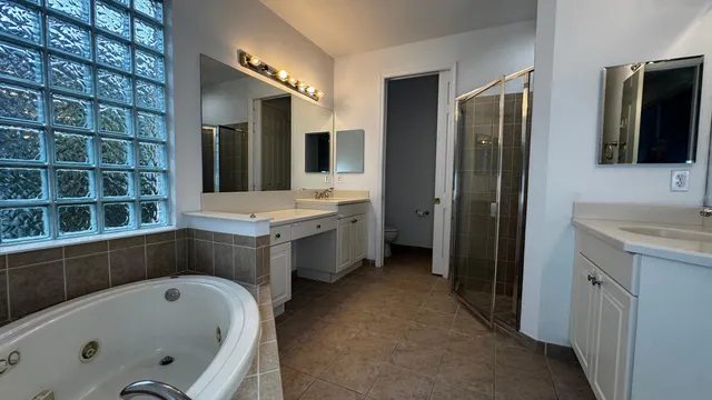 a bathroom with a tub a sink and a large mirror