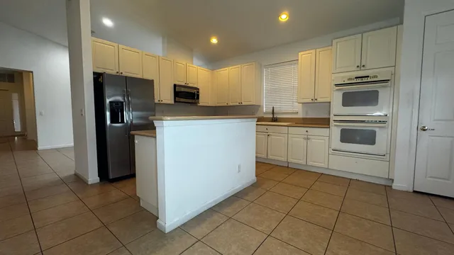 a kitchen with stainless steel appliances granite countertop a refrigerator and a stove top oven