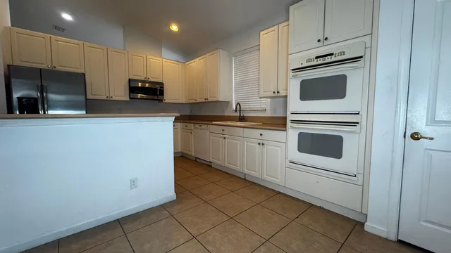 a kitchen with cabinets stainless steel appliances and sink