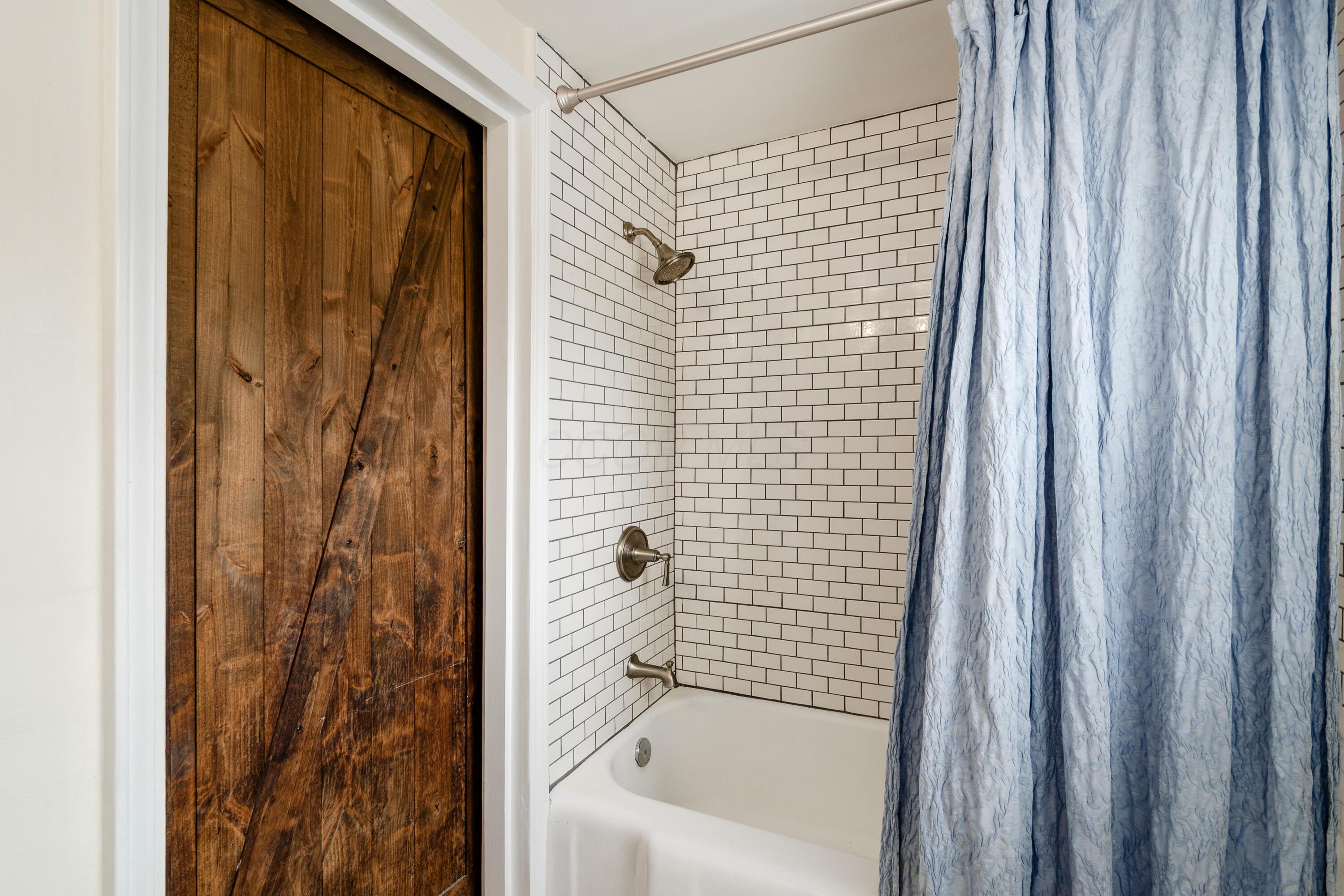 2805 Brandon Road Upper Arlington, OH 43221 - Photo 19 of 40 Tiled tub/shower combination with wood accent door.