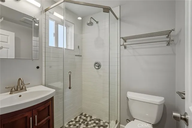 a bathroom with a shower a sink toilet and a mirror